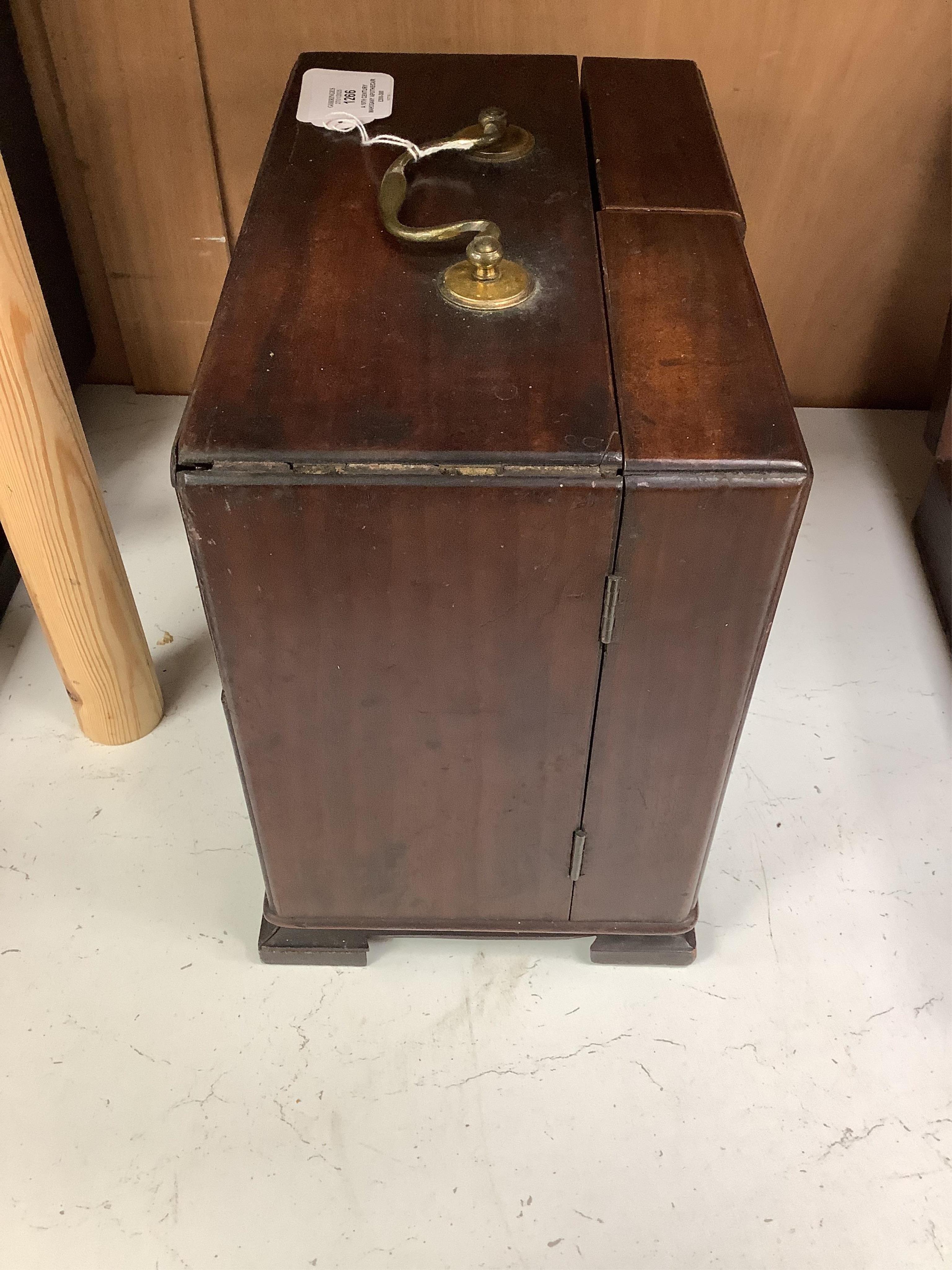 A 19th century mahogany apothecary cabinet, containing 20 bottles of various medicinal compounds and poisons, some sealed, all with paper labels, mainly for ‘C. Woollven, Operative & Dispensing Chemist, 108, High Street,